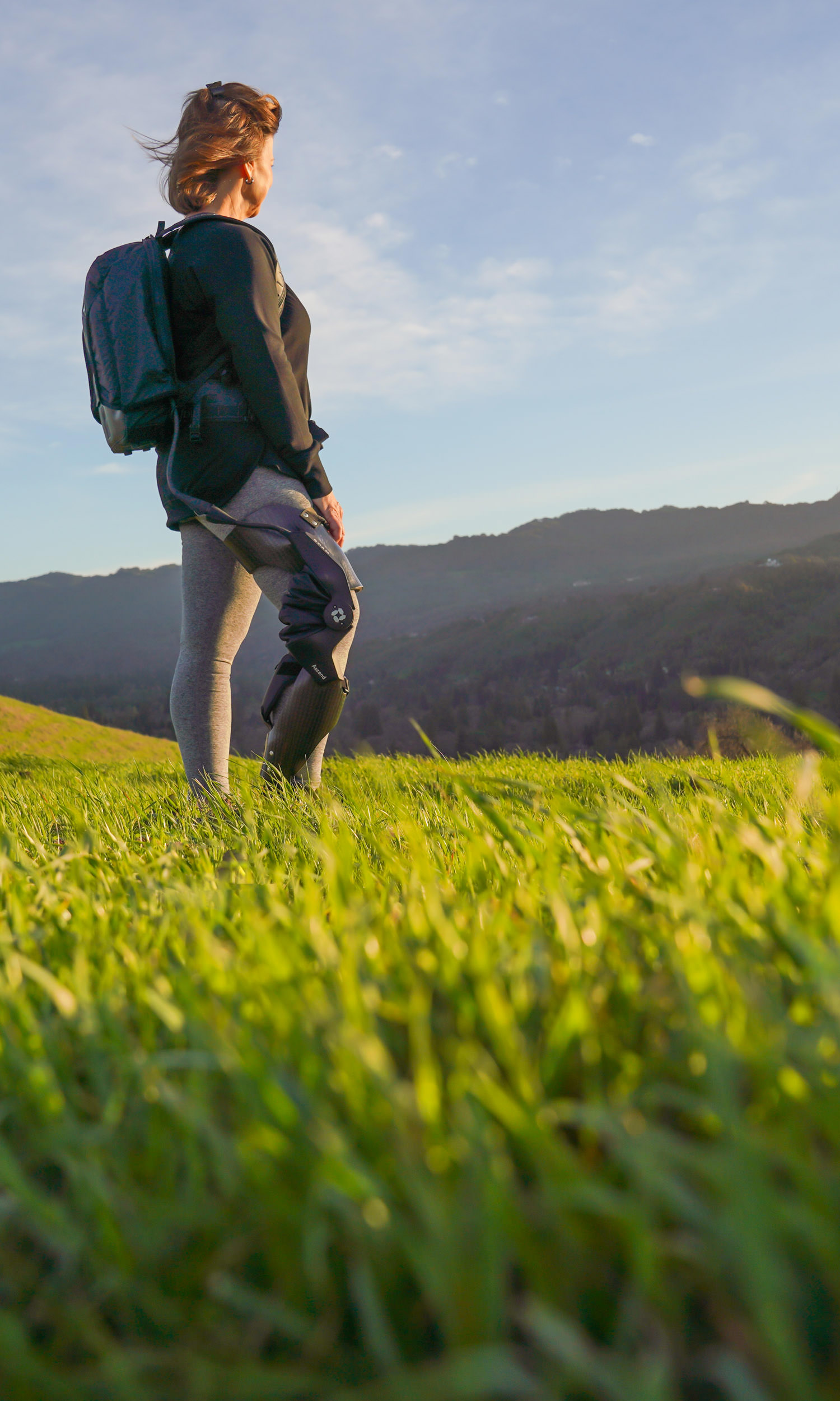 woman on a tall hill wearing a Roam device